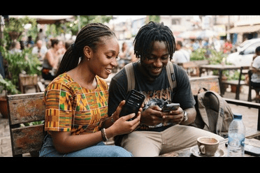 Two African friends sharing a mobile hotspot, one holding a smartphone while the other connects to it. 